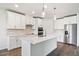 Modern kitchen with stainless steel appliances, white cabinets, and a large center island with white marble countertop at 1787 Draughton Dr, Zephyrhills, FL 33541