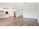 Open-concept living space featuring wood-look tile flooring and seamless flow to the kitchen at 1787 Draughton Dr, Zephyrhills, FL 33541