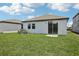 Well-maintained backyard with lush green lawn and a sliding glass door leading indoors at 1839 Brekey Way, Zephyrhills, FL 33541