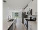 Bright kitchen featuring stainless steel appliances, a peninsula island, and plenty of counter space at 1839 Brekey Way, Zephyrhills, FL 33541