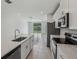 Open kitchen featuring a large island with a sink, stainless steel appliances and plenty of lighting at 1839 Brekey Way, Zephyrhills, FL 33541