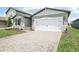 Inviting home featuring a two-car garage, stone details, and a brick-paved driveway at 1870 Draughton Dr, Zephyrhills, FL 33541