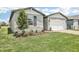 Charming one-story home featuring stone accents, a well-manicured lawn, and an attached two-car garage at 1870 Draughton Dr, Zephyrhills, FL 33541