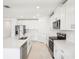 Modern kitchen featuring stainless steel appliances, white cabinetry, and an island sink at 1870 Draughton Dr, Zephyrhills, FL 33541