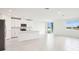 Open-concept living space with white tile floors, modern kitchen and natural light at 1870 Draughton Dr, Zephyrhills, FL 33541
