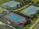 Aerial view showcases the basketball and tennis courts within the community, surrounded by lush landscaping and walking paths at 228 Lazy Shore Dr, Nokomis, FL 34275