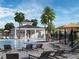 Community pool area with a pool house, lounge chairs, palm trees, and clear blue water, perfect for relaxation at 228 Lazy Shore Dr, Nokomis, FL 34275