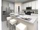 Modern kitchen with white cabinets, stainless steel appliances, granite countertops, and bar seating at 31596 Wild Grape Ln, Brooksville, FL 34602