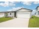 Newly built home featuring a two-car garage and manicured front lawn at 31643 Wild Grape Ln, Brooksville, FL 34602