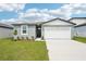 Charming one-story home featuring a two-car garage, a well-manicured lawn, and a welcoming facade at 31643 Wild Grape Ln, Brooksville, FL 34602