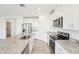 Bright, open kitchen featuring modern appliances, granite countertops, and sleek white cabinetry at 31643 Wild Grape Ln, Brooksville, FL 34602