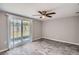 This bedroom features wood-look tile flooring and sliding glass doors to the backyard at 3206 Peterborough St, Holiday, FL 34690