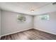 The bright bedroom offers vinyl flooring, neutral walls, and two windows at 3206 Peterborough St, Holiday, FL 34690