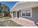 Close up of charming single-story home featuring a covered entrance and brick walkway to the front door at 3206 Peterborough St, Holiday, FL 34690