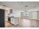 Open concept kitchen and living room featuring wood floors, neutral paint, and white cabinetry at 3206 Peterborough St, Holiday, FL 34690