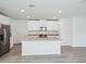 Open kitchen featuring an island, stainless steel appliances, granite countertops, and white cabinets at 437 Lazy Shore Dr, Nokomis, FL 34275