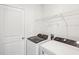 Clean laundry room with washer, dryer, wire shelving, and white door at 437 Lazy Shore Dr, Nokomis, FL 34275
