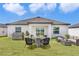 Backyard featuring a patio area with stylish seating, grill, and a well-maintained lawn at 10008 Last Light Gln, Parrish, FL 34219