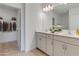 Bright bathroom with double sinks, white cabinetry, and a view into the closet at 10008 Last Light Gln, Parrish, FL 34219