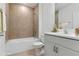 Bathroom showcasing a shower-tub combo and white cabinets with a large, bright mirror at 10008 Last Light Gln, Parrish, FL 34219