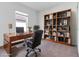 Functional home office with a wooden desk, bookshelves, and a comfortable chair at 10008 Last Light Gln, Parrish, FL 34219