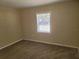 A cozy, carpeted bedroom featuring a bright window for natural light and a soothing atmosphere at 626 Belleview Blvd, Belleair, FL 33756