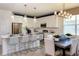Modern kitchen with white cabinets, stainless steel appliances, pendant lighting, and a dining area at 9548 Vibrant Lane, Venice, FL 34292
