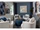 Cozy sitting area with plush chairs, ottoman, stylish decor, and a large window for natural light at 9548 Vibrant Lane, Venice, FL 34292