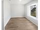 Bright bedroom features wood-look flooring and a window providing natural light at 22162 Weeks Blvd, Land O Lakes, FL 34639