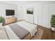 Bright bedroom with a large bed, wood floors, white walls, and a closet with shutter doors at 22162 Weeks Blvd, Land O Lakes, FL 34639