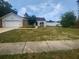 Inviting home exterior with a two-car garage, a lovely lawn, and mature trees at 22162 Weeks Blvd, Land O Lakes, FL 34639