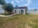 Charming home exterior with arched entry, healthy tree, and a low-maintenance landscaped yard at 22162 Weeks Blvd, Land O Lakes, FL 34639