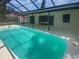 Relaxing screened pool area with sparkling turquoise water and covered seating space at 22162 Weeks Blvd, Land O Lakes, FL 34639