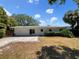 Spacious backyard with a patio, lush greenery, and a well-maintained lawn area at 4825 W Bay Court Ave, Tampa, FL 33611