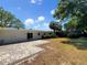 A spacious backyard featuring a brick patio, lush lawn, mature trees, and private surroundings at 4825 W Bay Court Ave, Tampa, FL 33611