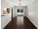 Dining area with modern lighting, dark wood floors, and sliding doors to the outdoor patio at 4825 W Bay Court Ave, Tampa, FL 33611