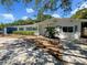 Charming single-story home with a well-manicured lawn, beautiful landscaping, and a concrete driveway at 4825 W Bay Court Ave, Tampa, FL 33611
