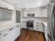 Updated kitchen with white cabinets, stainless steel appliances, and a breakfast bar at 4825 W Bay Court Ave, Tampa, FL 33611