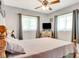 Bright bedroom showcasing a bed, two windows with curtains and dresser with a TV at 5208 30Th W St, Bradenton, FL 34207