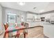 Cozy eat-in kitchen features white cabinets, stainless sink, and wood-look flooring at 5208 30Th W St, Bradenton, FL 34207