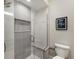 Modern shower with glass enclosure featuring tiled walls, shower head, and a built-in seat at 8035 St Simons St # 8035, University Park, FL 34201