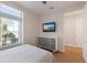 Bedroom with a dresser, mounted TV, and bright window at 8035 St Simons St # 8035, University Park, FL 34201