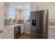 Bright, well-lit kitchen featuring stainless steel refrigerator, wine storage, and decorative backsplash at 8035 St Simons St # 8035, University Park, FL 34201