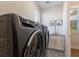Contemporary laundry area showcasing washer and dryer with patterned tile floor, sink, and storage at 8035 St Simons St # 8035, University Park, FL 34201