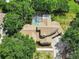 Aerial view of a private home with a screened-in pool surrounded by lush greenery and tall trees at 20003 Holly Lake Pl, Lutz, FL 33558