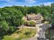 A beautiful aerial view showcases the home among mature trees and a long driveway at 20003 Holly Lake Pl, Lutz, FL 33558