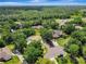 Lush, green aerial view showcasing the property's setting among mature trees and a nearby highway at 20003 Holly Lake Pl, Lutz, FL 33558