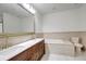 Bathroom featuring double sinks, soaking tub, and ceramic tile at 20003 Holly Lake Pl, Lutz, FL 33558