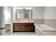 Bathroom with double sinks, bathtub, and dark wood cabinets at 20003 Holly Lake Pl, Lutz, FL 33558