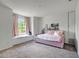 Bright bedroom with pink daybed, window seat, and plush gray carpet at 20003 Holly Lake Pl, Lutz, FL 33558